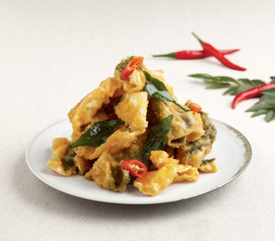 Crispy fried Salted Egg Yolk Fish Skin served in a dish isolated on wooden board side view dark background